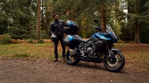 Right hand side of the Triumph Tiger Sport 800 Tour in a forest with a man standing behind it