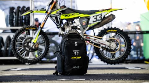 Aldek backpack on the floor with a Triumph off road bike in the background