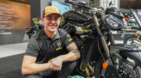 Dom Herbertson crouched next to Triumph Street Triple RS