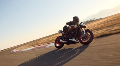 Side view of a rider on the Triumph Street Triple RX riding on a track