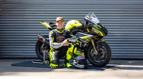 Dom Herbertson kneeling next to Triumph Street Triple 765