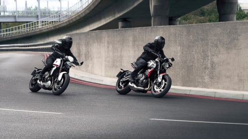 Two Triumph Trident 660s riding in urban setting