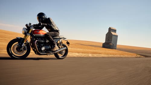 Person riding Triumph Speed Twin 1200 RS through dry roads