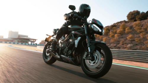 An image of a motorcycle riding in the sunset on a track