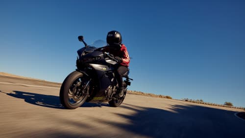 Triumph Daytona 660 in satin granite and satin jet black riding on mountain road