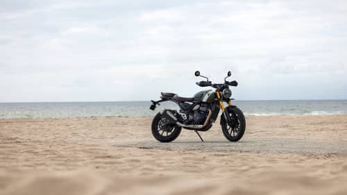 Triumph Scrambler 400 X stationary on a beach