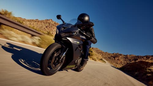Triumph Daytona 660 in satin granite and satin jet black riding on mountain road