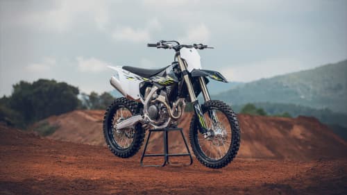 Stationary Triumph TF 250 X on muddy hill