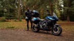 Right hand side of the Triumph Tiger Sport 800 Tour in a forest with a man standing behind it