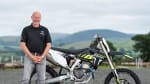 Paul Edmonson standing next to a Triumph Motorcycles TF 250-X