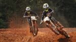 two riders onboard Triumph TF 250-Xs riding on Motocross track