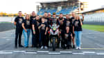 Group of people surrounding a racer on Triumph Daytona 660