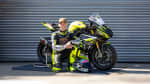 Dom Herbertson kneeling next to Triumph Street Triple 765