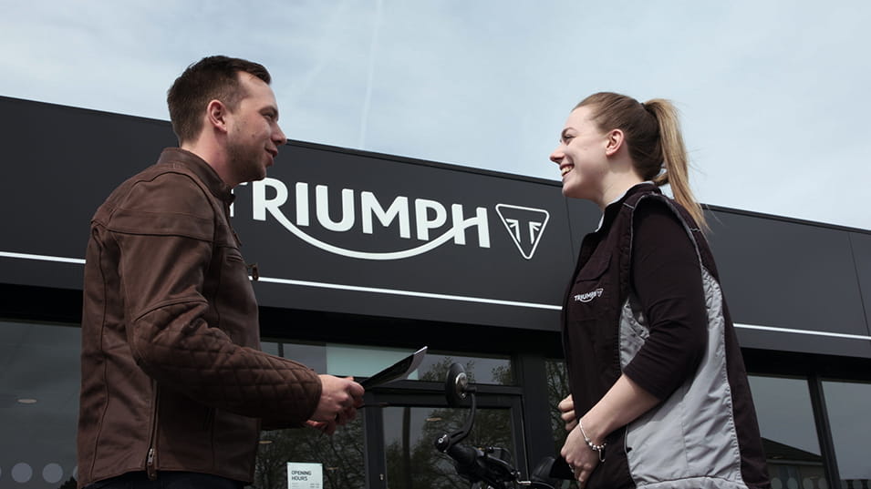 Man and woman outisde Triumph dealership