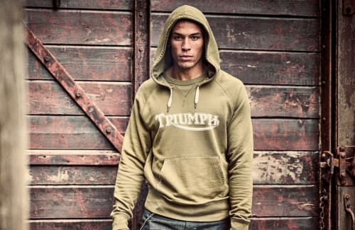 Man standing outside shed wearing Triumph Lifestyle Parka Hoodie
