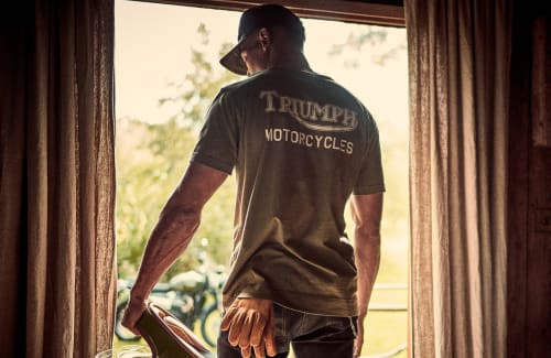 Man in window looking outside wearing Triumph Lifestyle Tee