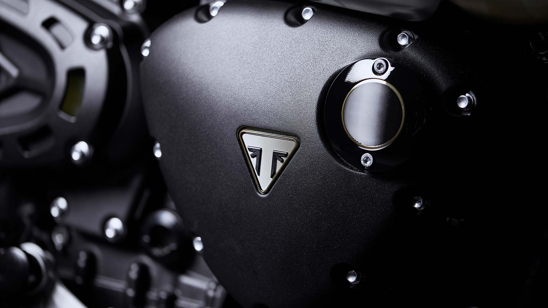 Close up of the Triumph Scrambler 1200 Bond Edition engine badges with gold accents