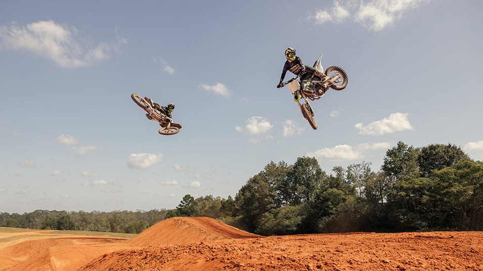 Two motocross riders jumping a Triumph TF 250-X at Motocross track
