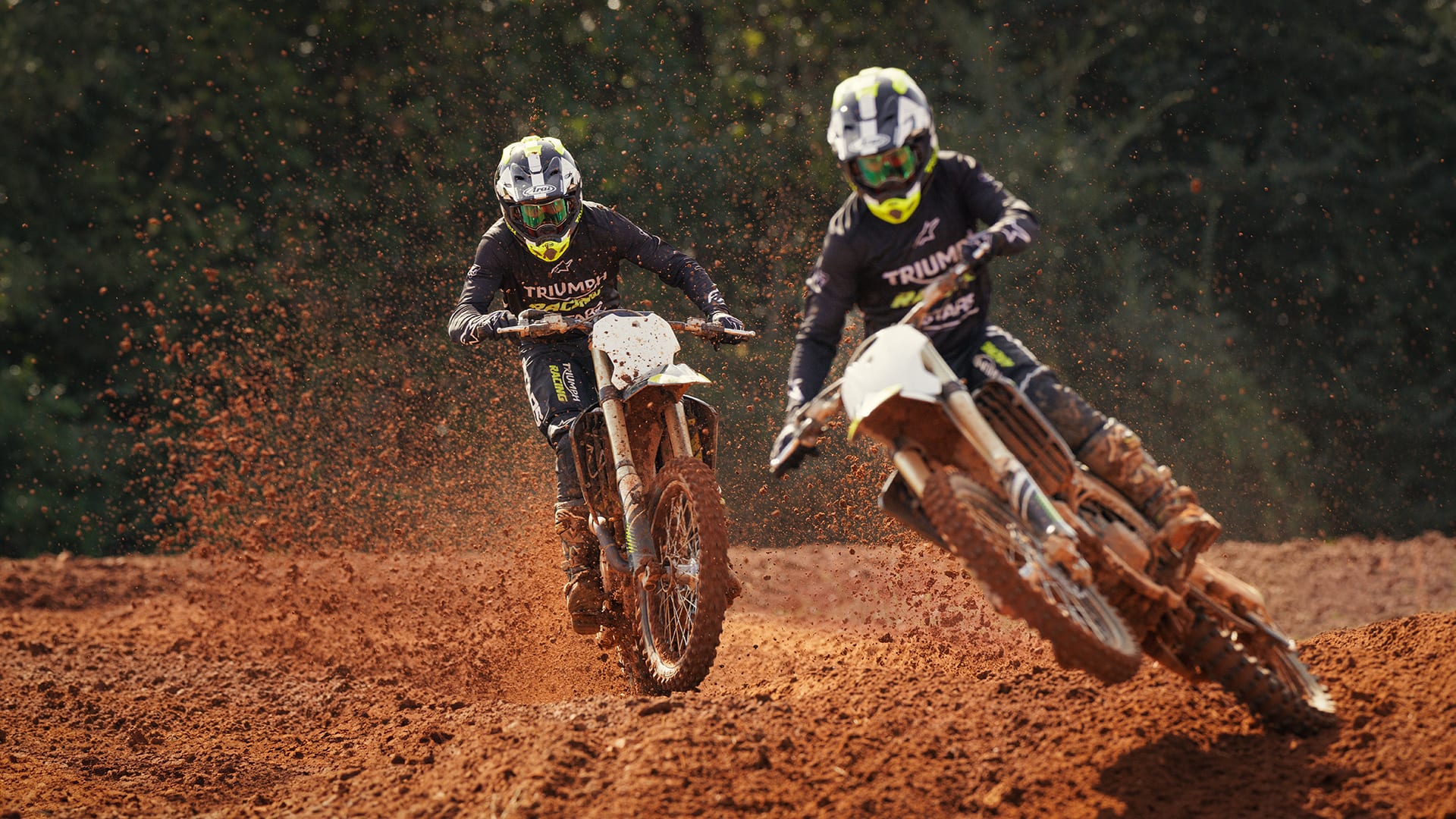 two riders onboard Triumph TF 250-Xs riding on Motocross track