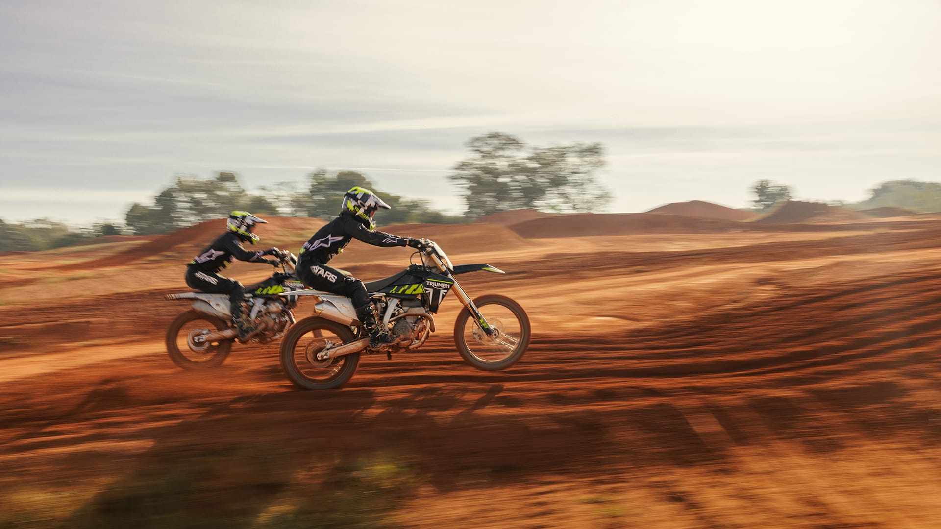 two riders onboard Triumph TF 250-Xs riding on Motocross track
