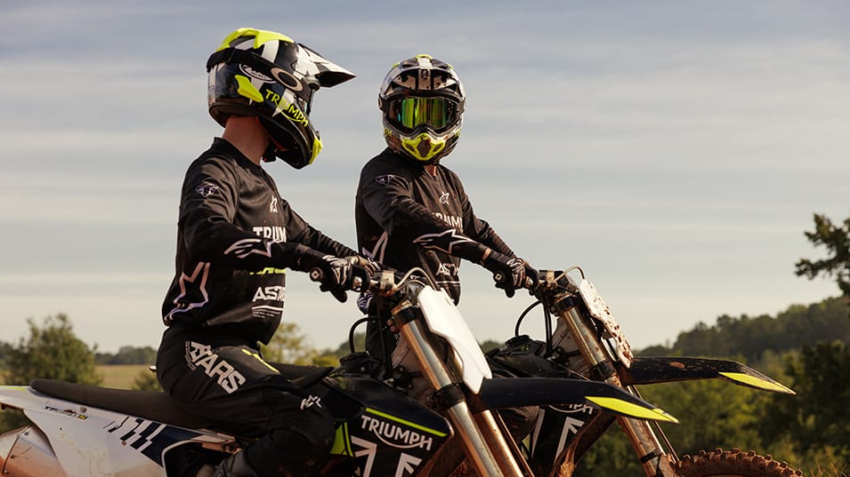 Two motocross riders talking sat on Triumph TF 250-X