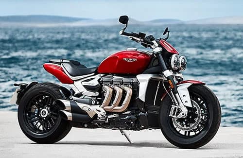 Triumph Rocket 3 R in Koroshi Red muscular and magnificent side profile at seafront