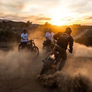 Group of friends riding Triumph motorbikes while wearing Triumph Heritage
