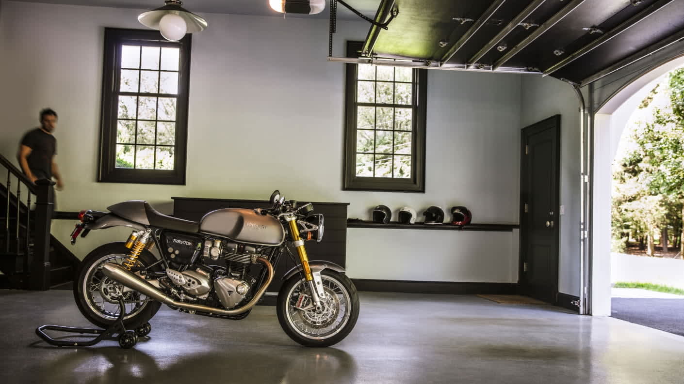 Static Triumph Thruxton R on paddock stand in garage setting