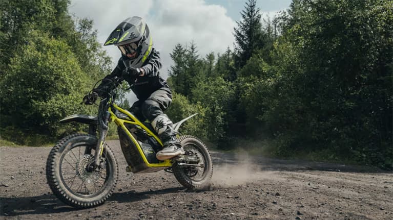 Young boy riding Triumph OSET on dirt road