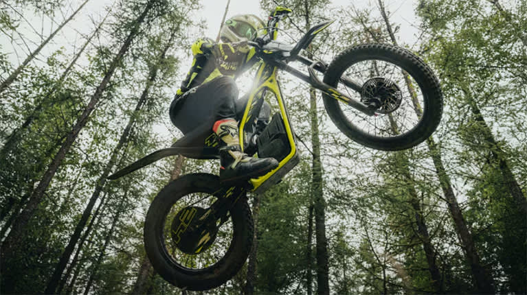 Triumph OSET in the air with a forest background