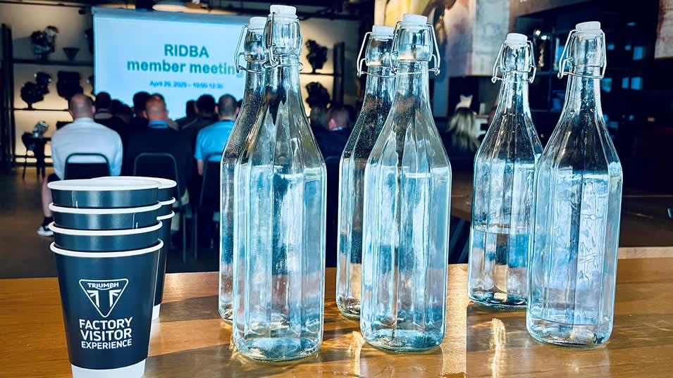 Glass water bottles and Triumph branded cups set up for an event