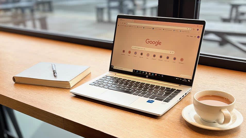 Hot desk space with laptop, notebook and coffee cup