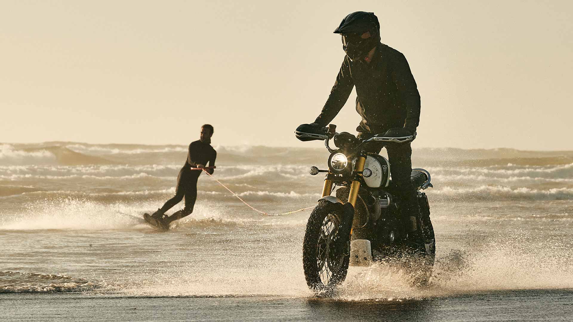 Triumph Scrambler 1200 XE being ridden through waves on a beach