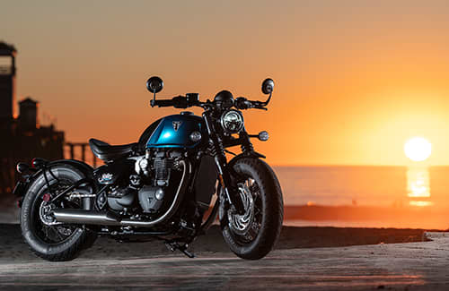 Triumph motorcycles Bonneville Bobber with sunset in the distance