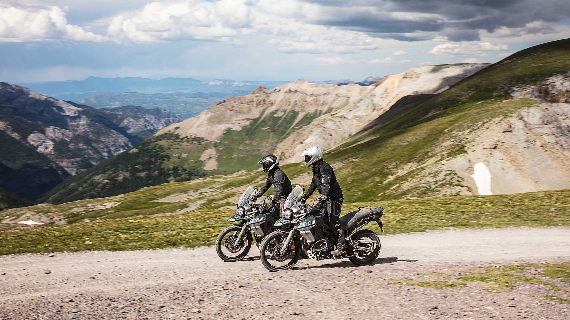 Riders on Triumph Tiger 800 XCA riding along across mountainous terrain