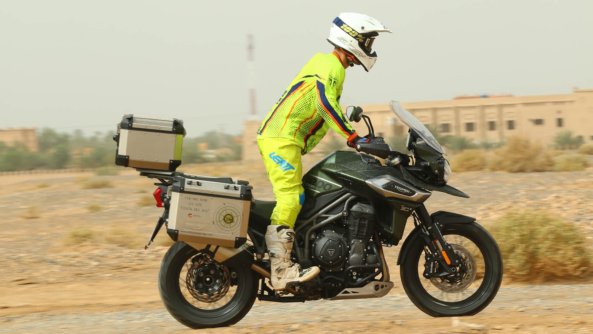 A solo rider riding Triumph Tiger 1200 through a desert landscape