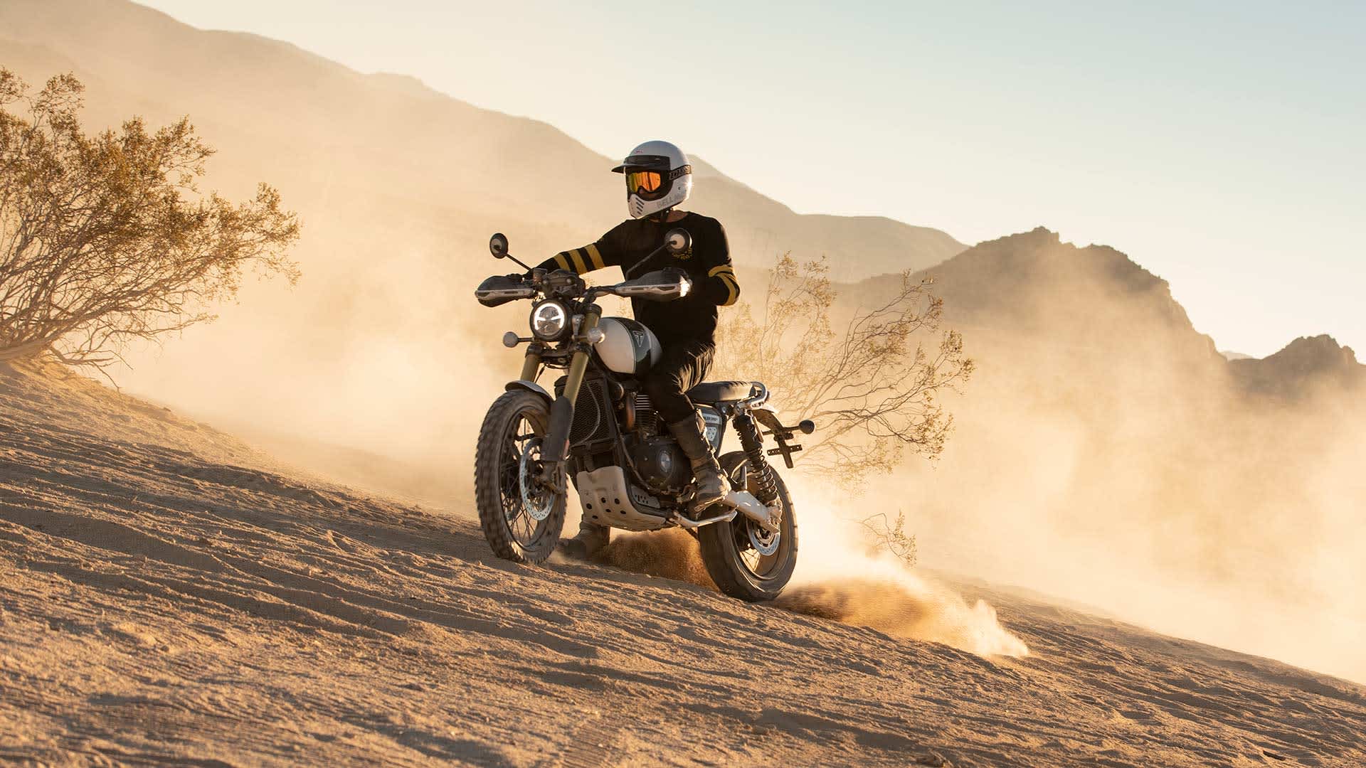 An experienced rider swiftly riding on the Scrambler 1200 XE on a desert terrain