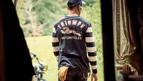 Man walking out of house in Triumph Long Sleeve Tee