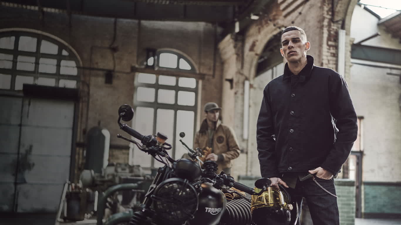 2 men in winter jackets stood next to motorcycles