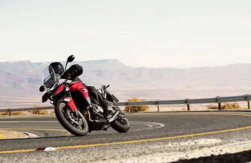 A Korosi Red Tiger 900 GT Pro taking a bend in the road