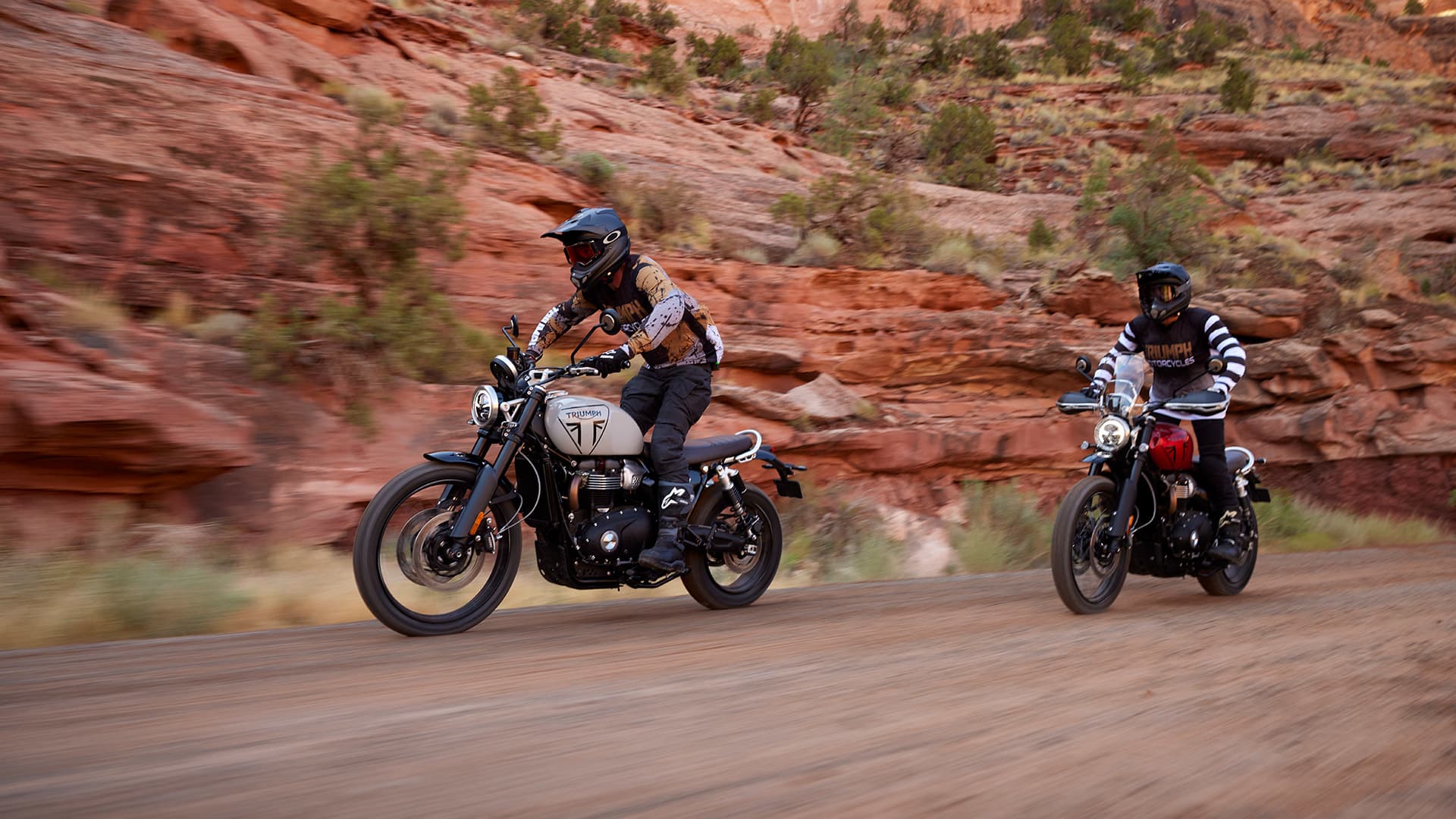 Rider stood behind a Triumph Scrambler 1200 X in carnival red
