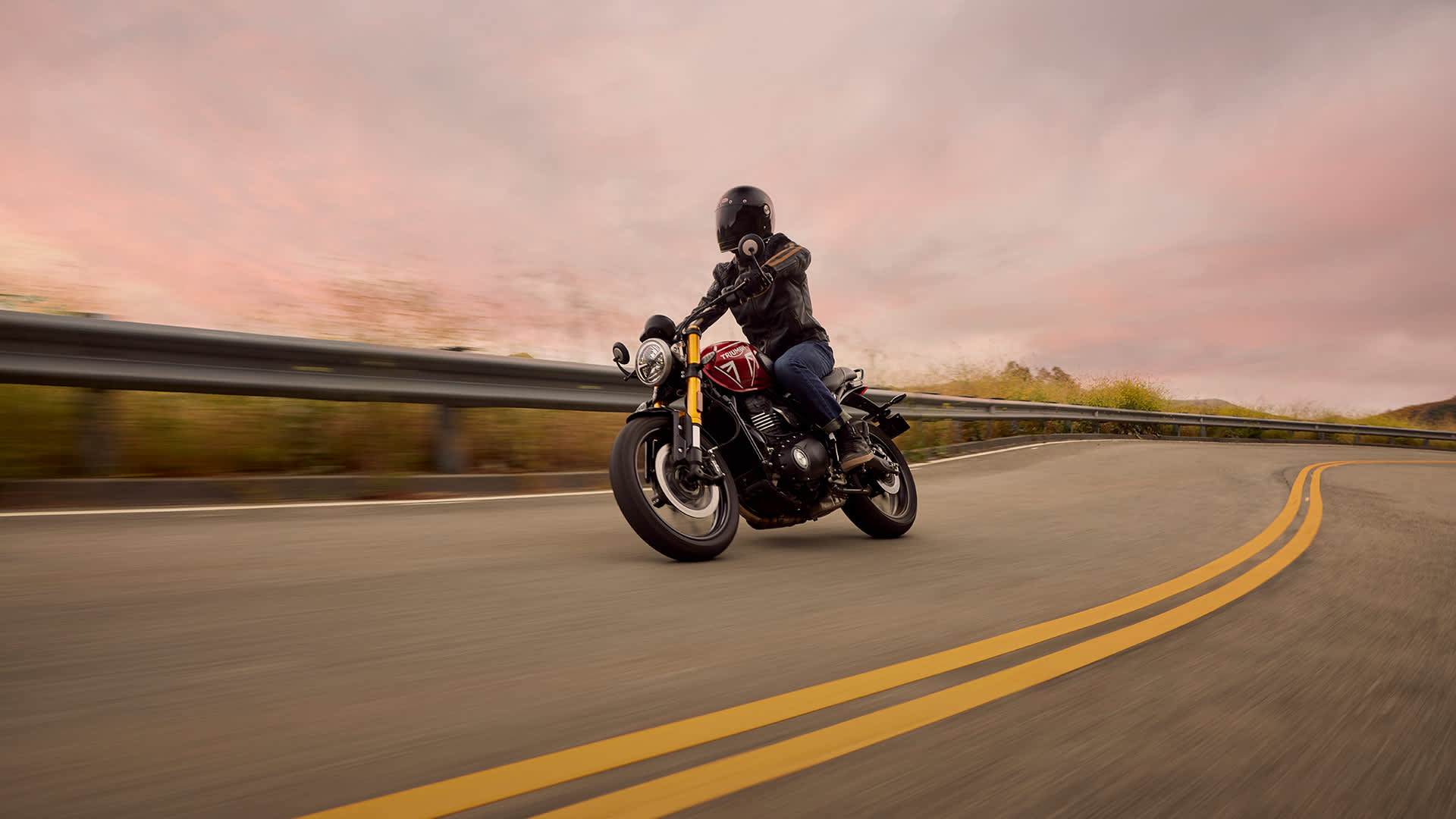 Rider on Triumph Speed 400 in Carnival red on a road