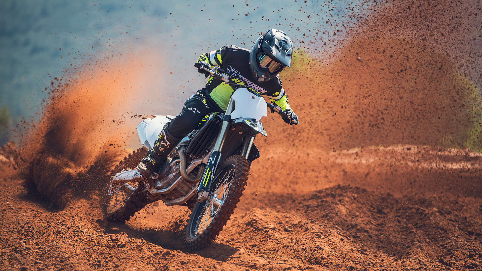 Rider on Triumph TF 450-X riding through muddy track