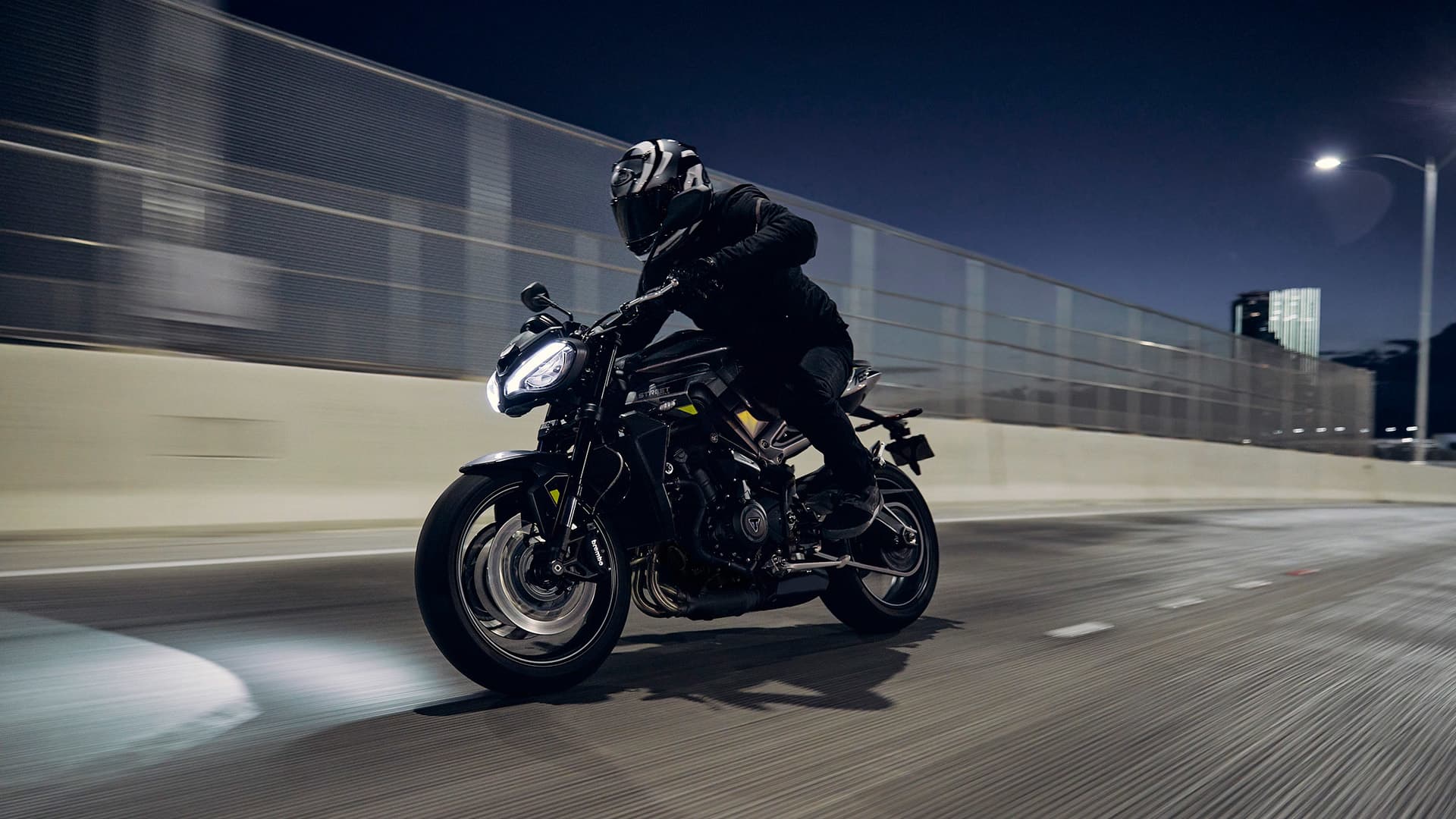 Rider on Triumph Street Triple 765 R riding on a road at night