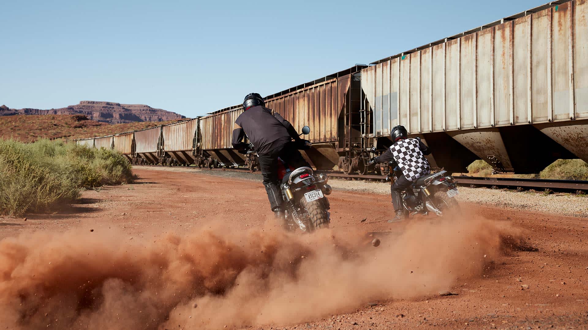 Triumph Scrambler 1200 XE Riding Shot Back View Along Side Train