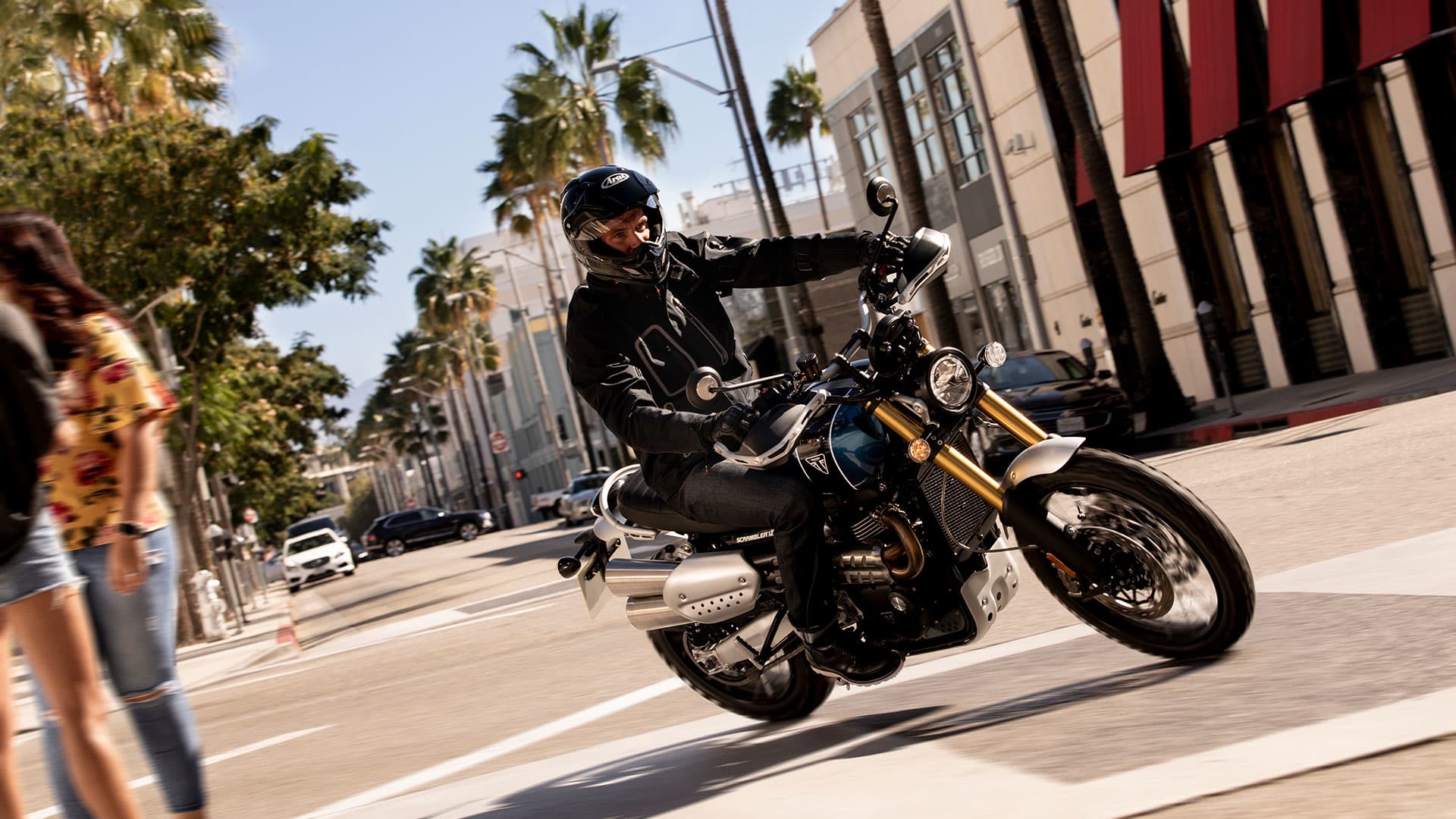 Triumph Scrambler 1200 riding around a corner in an urban suburb
