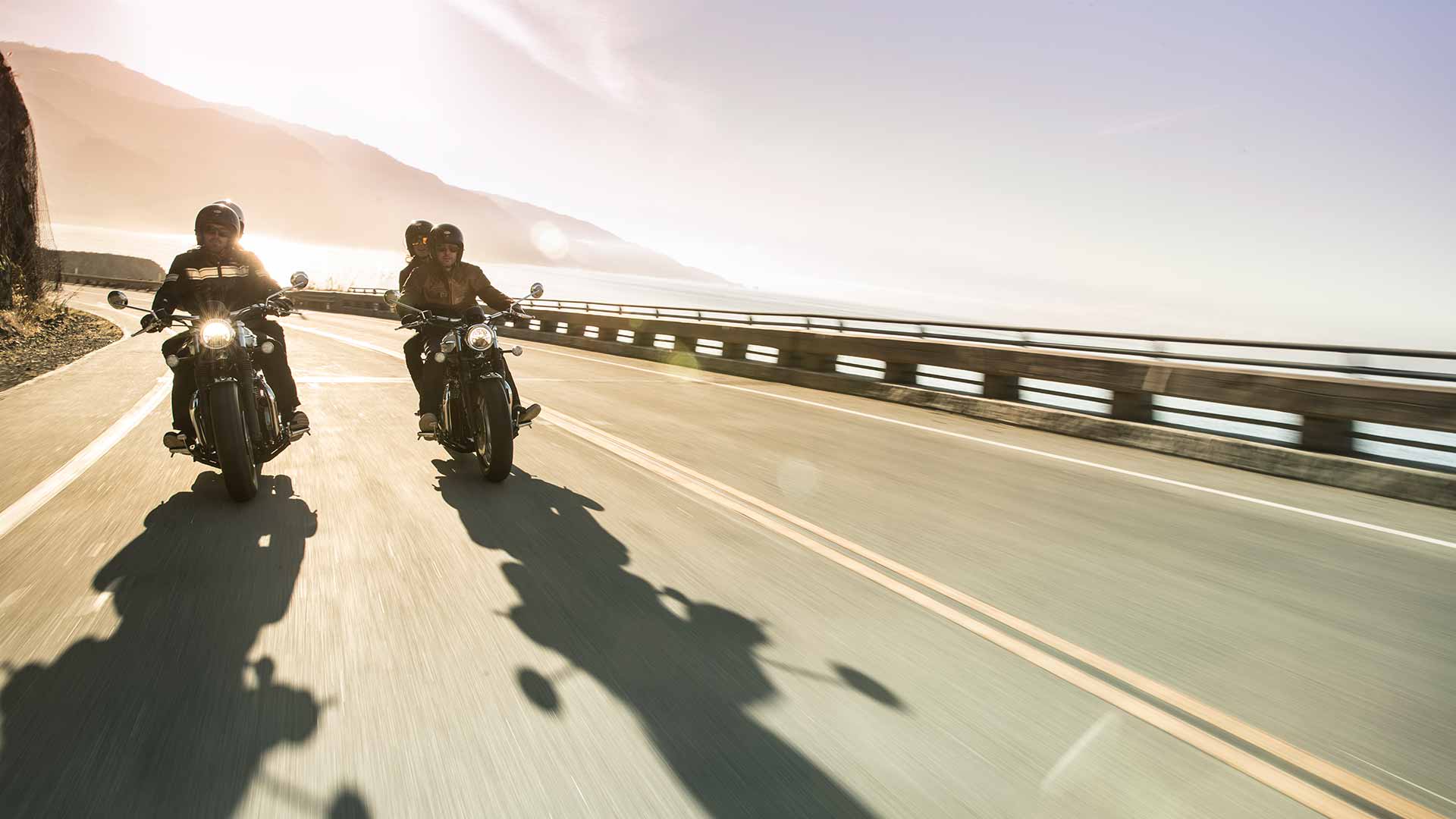 Pair of triumph bonneville speedmasters riding down road