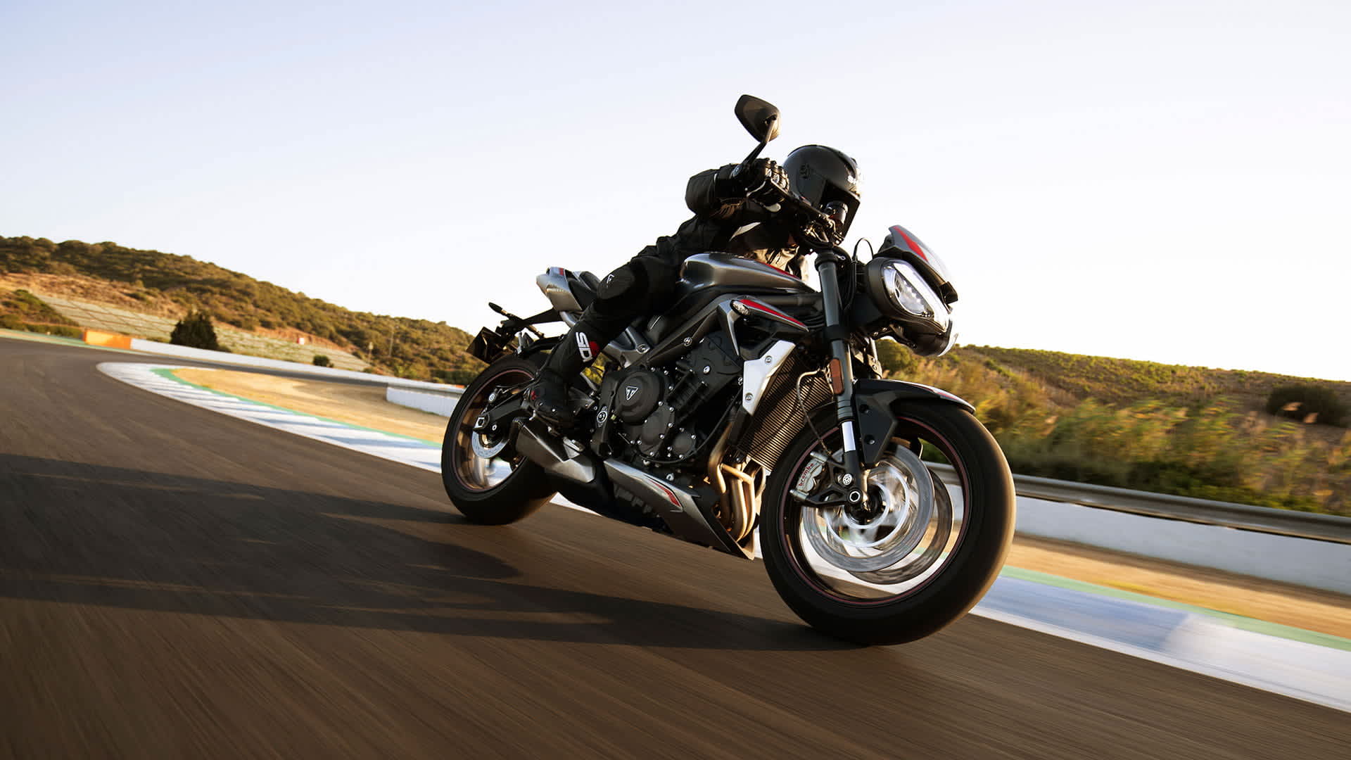 New Triumph Street Triple RS in Silver Ice powering down a racetrack
