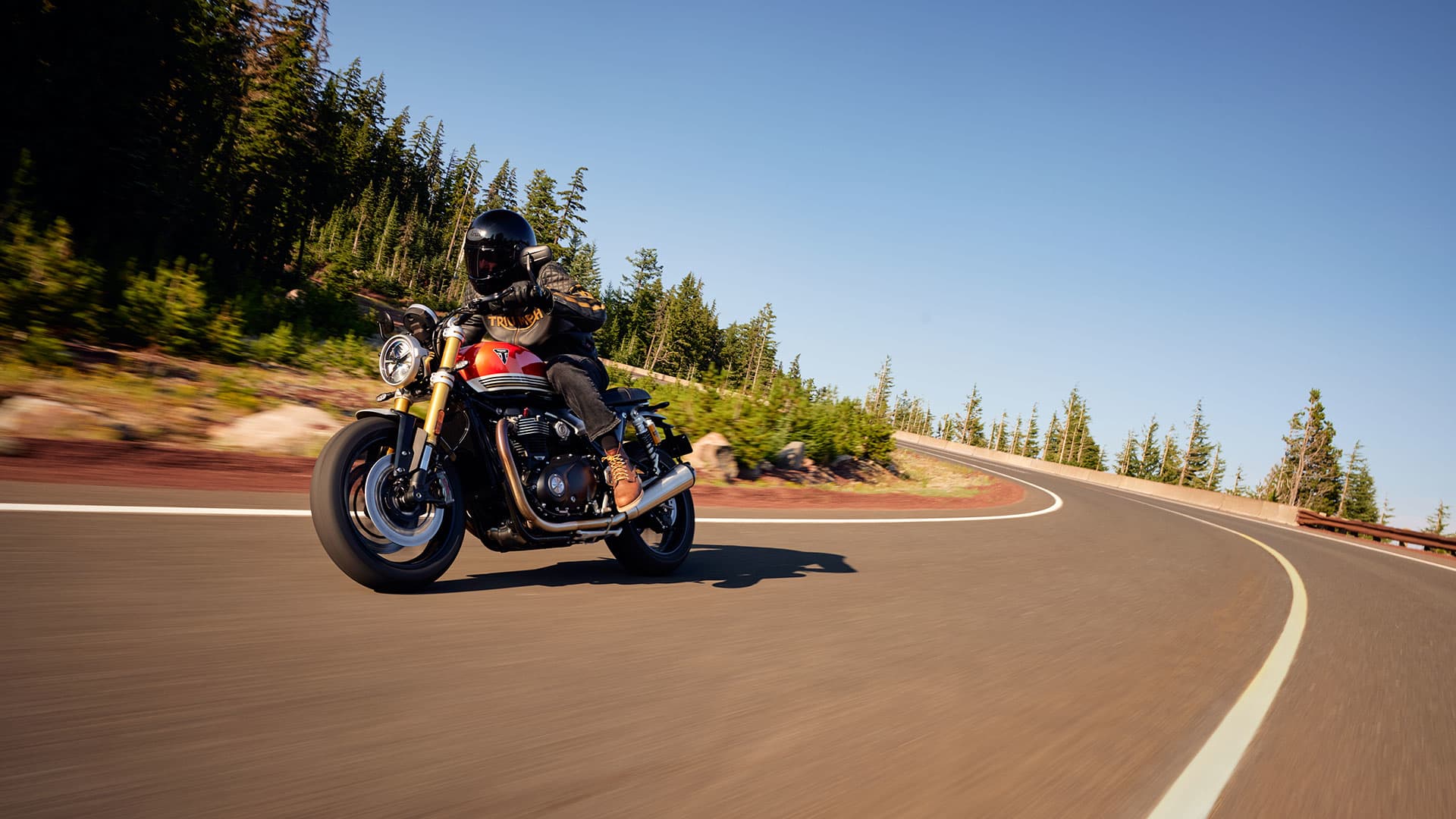 Triumph Speed Twin 1200 RS riding shot on a road through the forest
