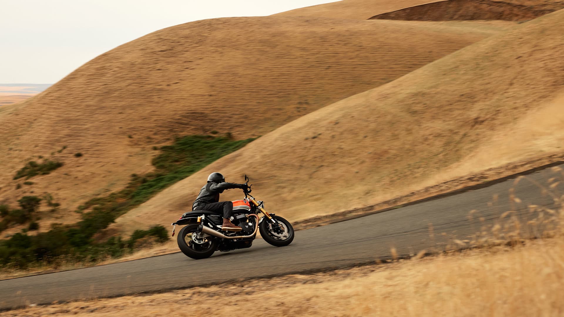 Triumph Speed Twin 1200 RS riding shot on a road taken from behind
